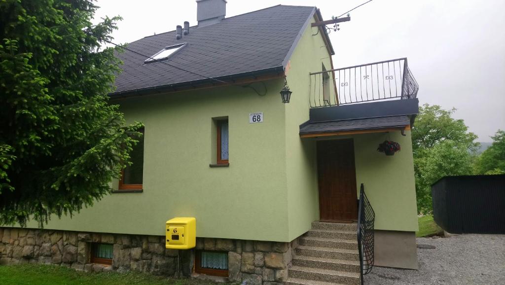 een groen huis met een trap en een balkon bij Nad Białką in Bielsko-Biala