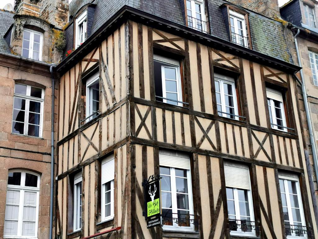 ディナンにあるLes appartements du Marchéの通りに面した窓のある古い木造の建物