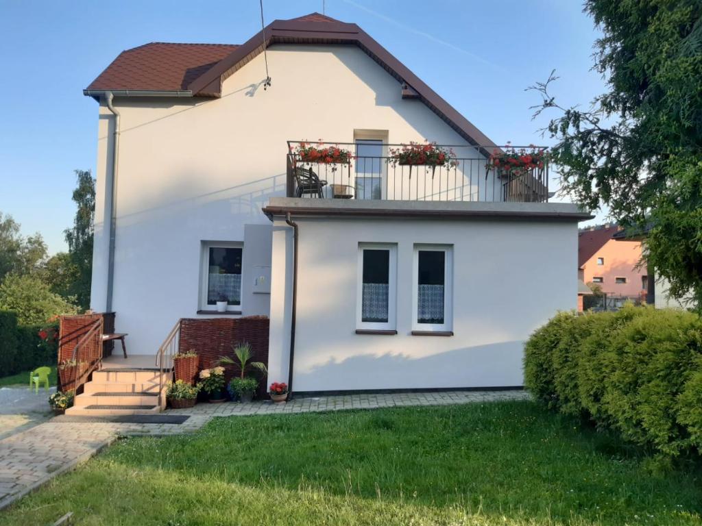 Cette maison blanche dispose d'un balcon. dans l'établissement Górski Zakątek, à Meszna