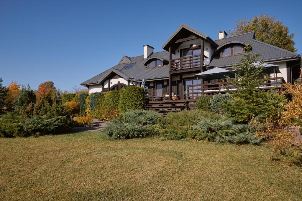 una gran casa en una colina con un patio en PUJSZANY AGROTURYSTYKA, en Skierbieszów