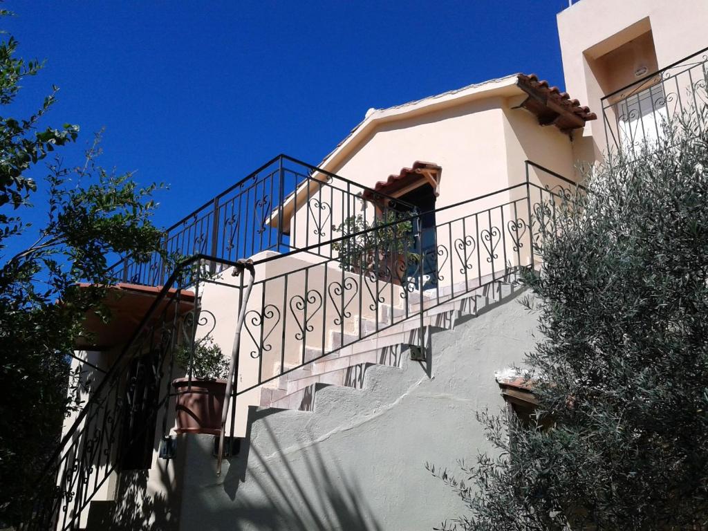 una escalera que conduce a una casa con un cielo azul en Ktima Tzamika en Episkopí- Rethimno