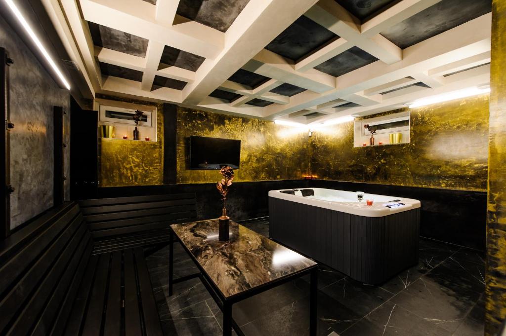La salle de bains est pourvue d'une baignoire et d'une table. dans l'établissement Apartments in Kaunas city centre with Jacuzzi bath, à Kaunas