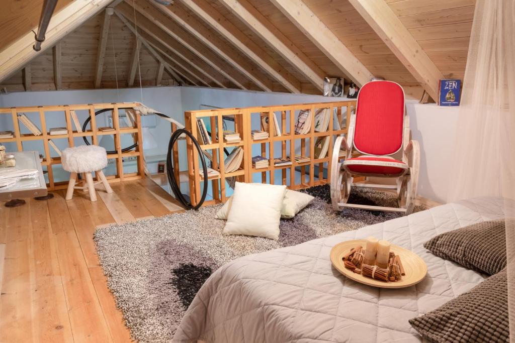 Zimmer mit einem Bett und einem roten Stuhl in der Unterkunft Sinanis Garden House in Volos