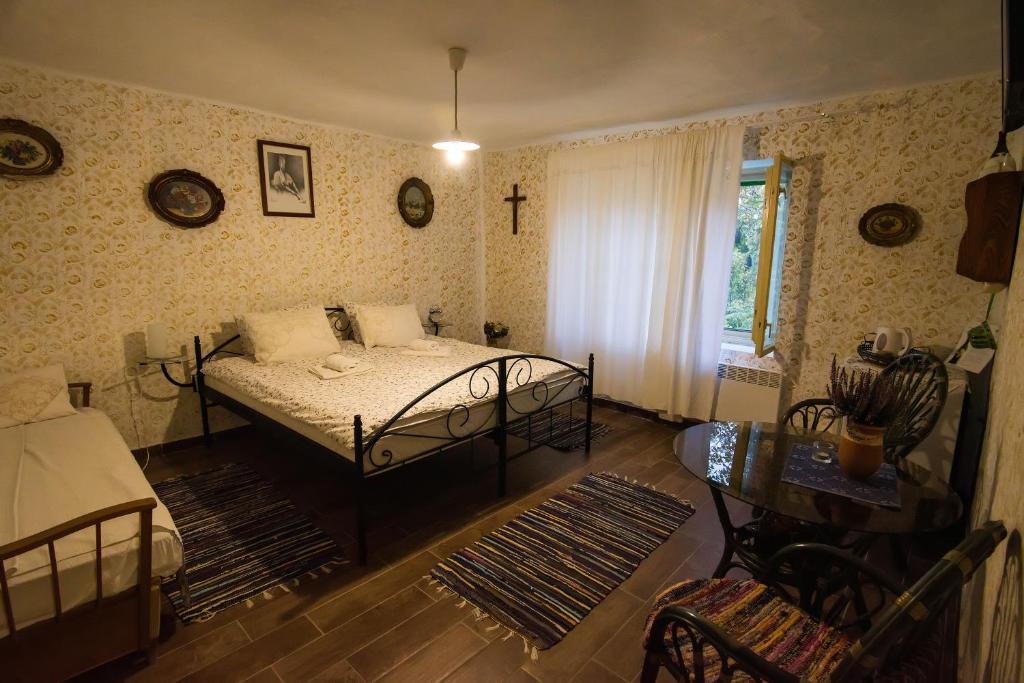 a bedroom with a bed and a cross on the wall at Ribarska kuća - Ilok ,tradicijska kuća-sobe in Ilok