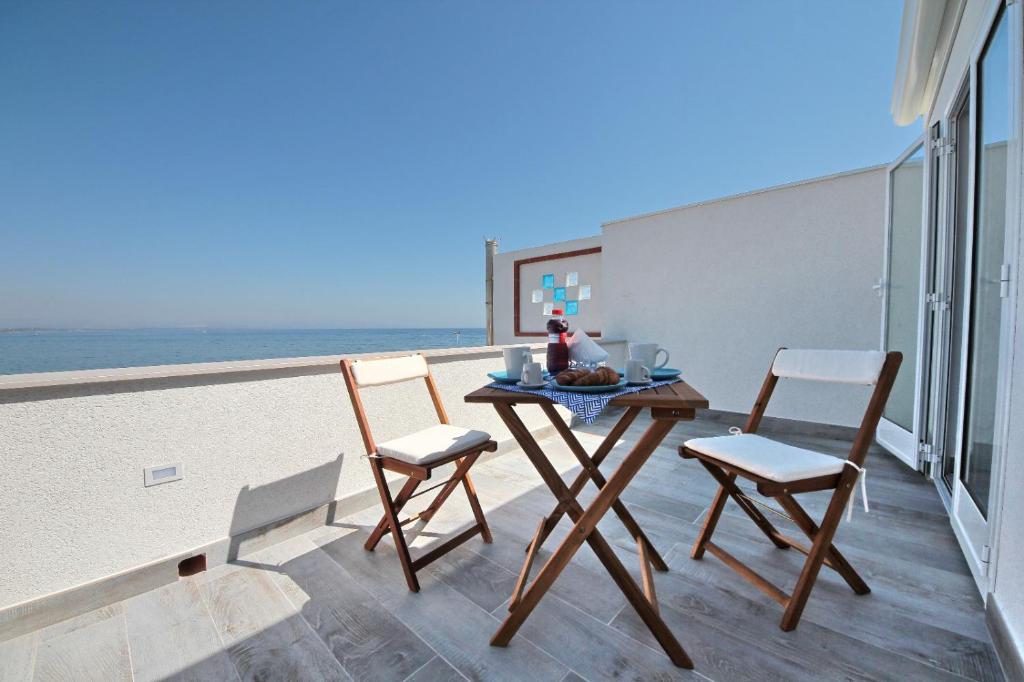Amareilmare1 في مارزاميمي: طاولة وكراسي على شرفة مع الشاطئ