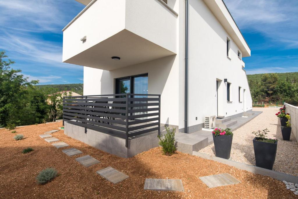 a white church with a black railing on the side at Apartman Jugo in Punat