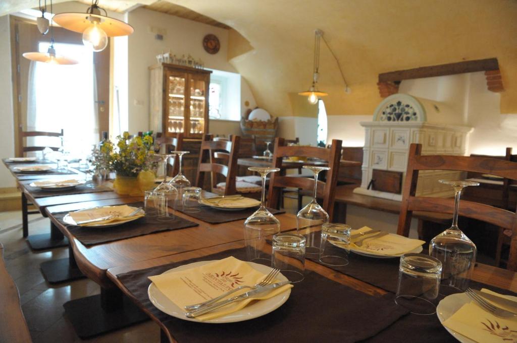 a dining room with a long wooden table with glasses at Agriturismo Sol De Montalto in Rivoli Veronese