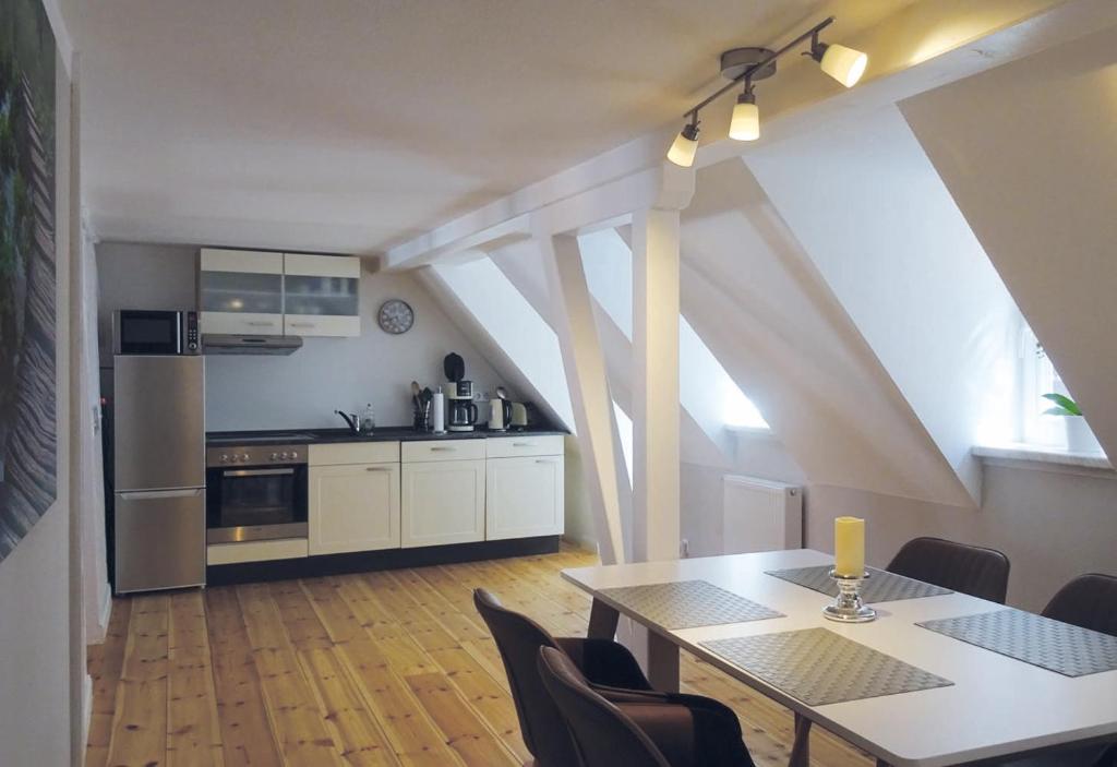 een keuken met een tafel en een aantal stoelen en een tafel en een keuken bij Ferienwohnungen Ziesing am Schlossberg in Quedlinburg