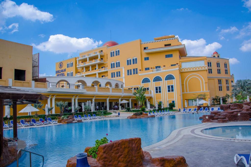 a resort with a large swimming pool in front of buildings at Helnan Dream Hotel and Conference Center in 6th Of October