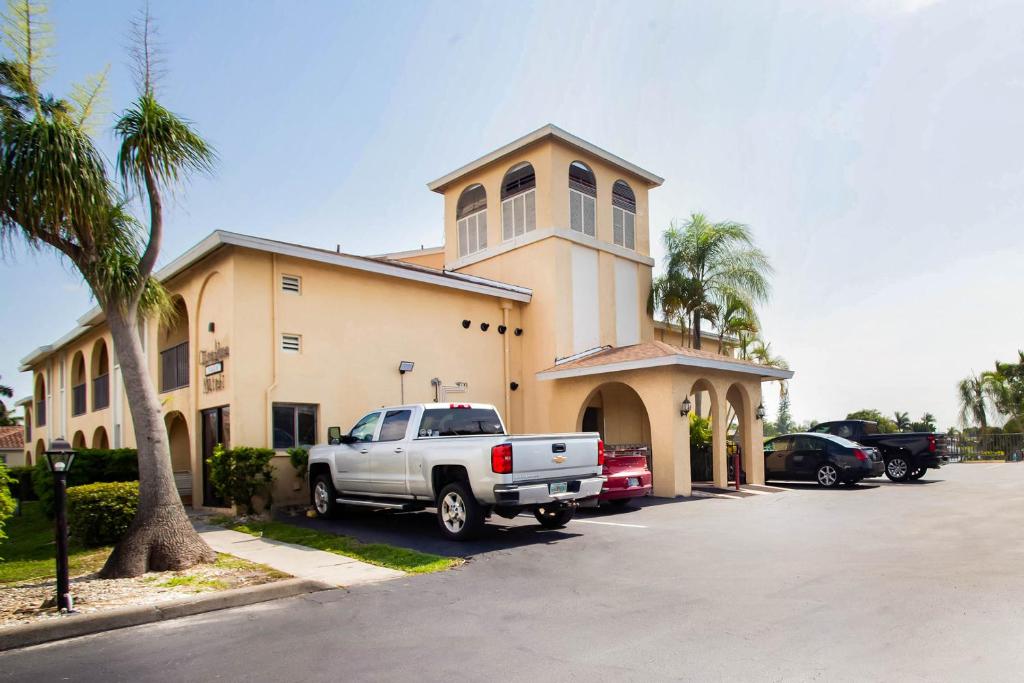 OYO Waterfront Hotel- Cape Coral Fort Myers, FL في كيب كورال: شاحنة متوقفة في موقف للسيارات أمام مبنى