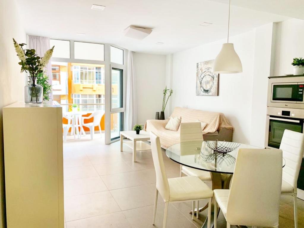 eine Küche und ein Wohnzimmer mit einem Tisch und Stühlen in der Unterkunft Sagasta BeachFront Balcony by Canary365 in Las Palmas de Gran Canaria
