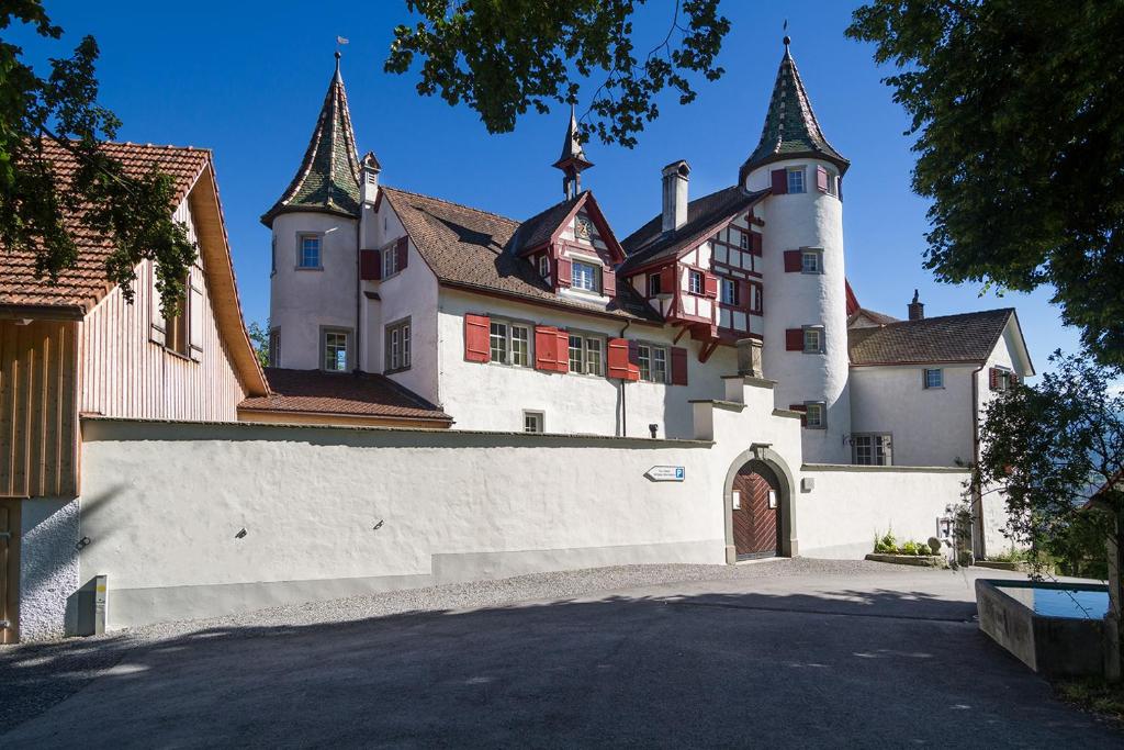 duży biały budynek z bramą i wieżyczkami w obiekcie Schloss Weinstein w mieście Marbach St Gallen