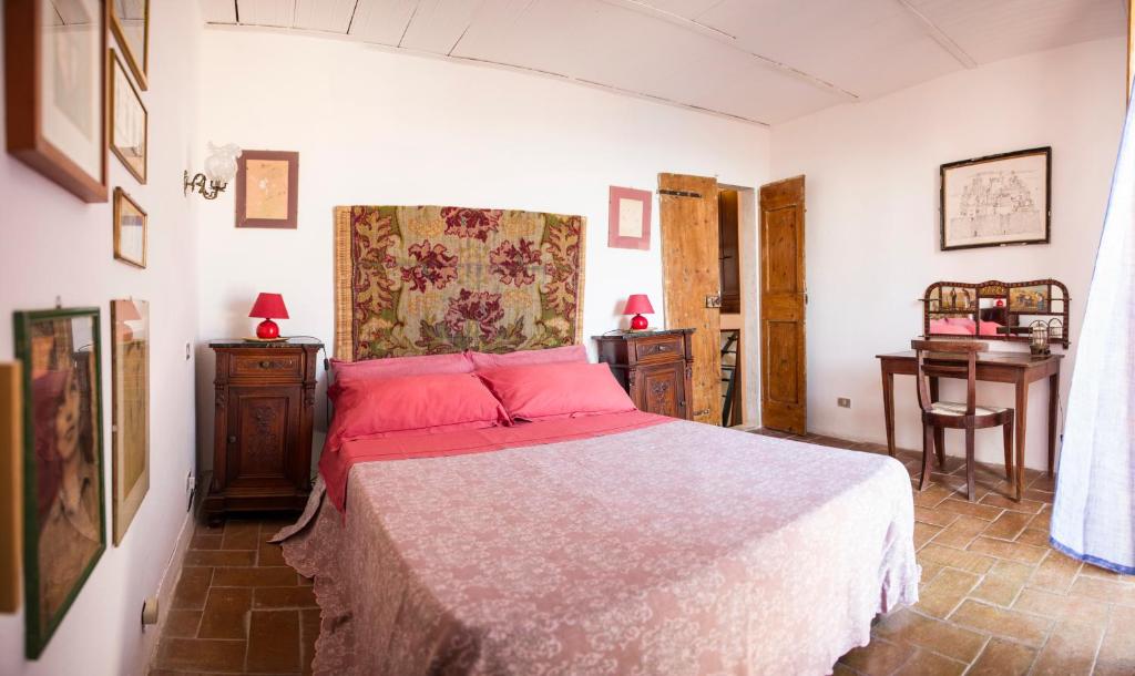 a bedroom with a large bed with red pillows at Borgo Antico - Torre Pugliola in Lerici