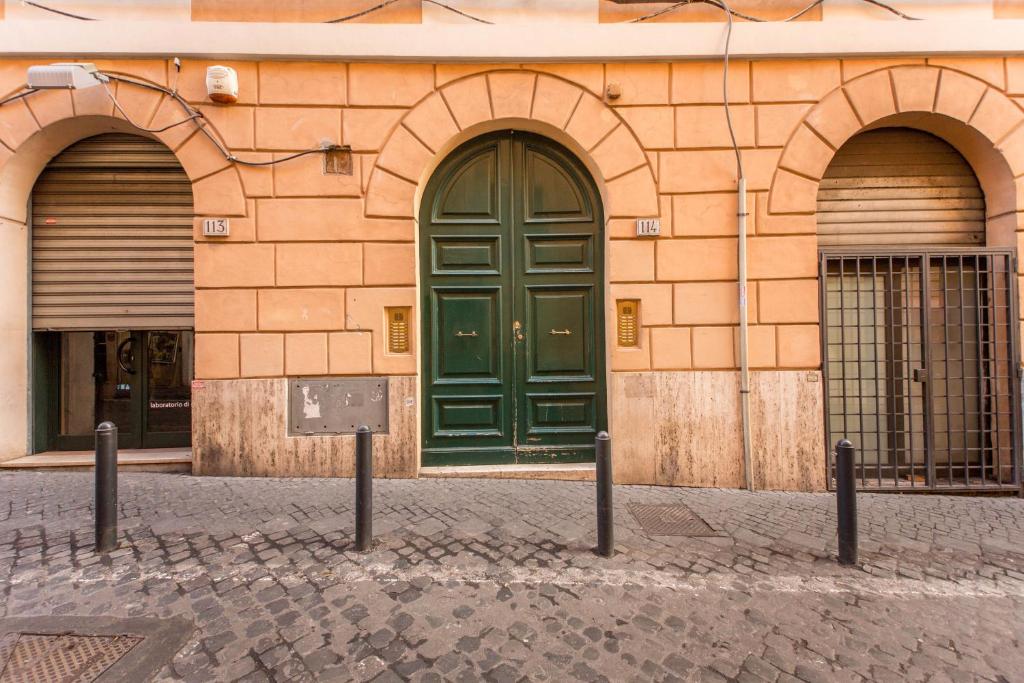 un edificio con una puerta verde en una calle en Boschetto, en Roma