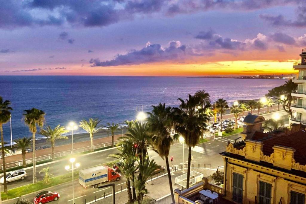 a view of a city with the ocean at sunset at Sea View - Promenade des Anglais 1 Bdr in Nice