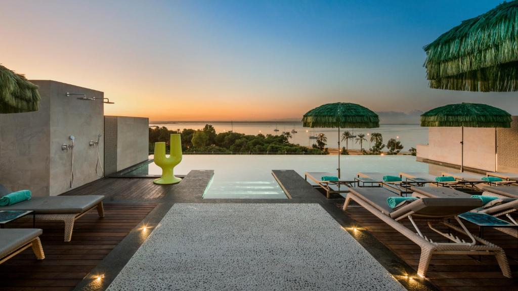 a pool with lounge chairs and the ocean in the background at El Llorenc Parc de la Mar - Adults Only (+16) in Palma de Mallorca