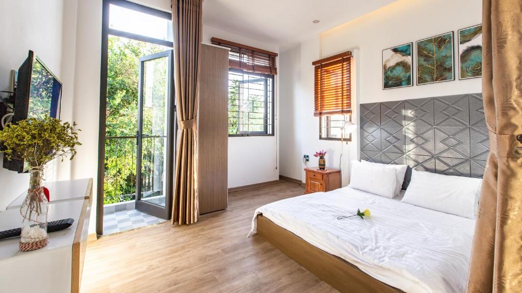 a bedroom with a large bed and large windows at Seashine Apartment in Da Nang