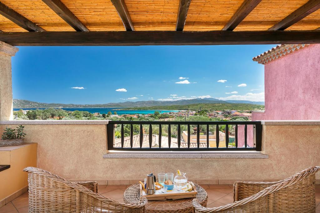a balcony with a table and chairs and a view at Homey Experience - Terrace Sea View Apartment in Olbia