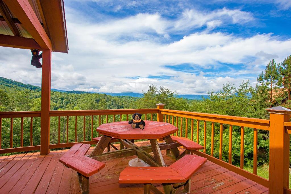 a toy monkey sitting on a picnic table on a deck at Kori's Mountain View, FREE tickets each paid day, Theater Room, Hot Tub, Game Room, WIFI!!! in Townsend