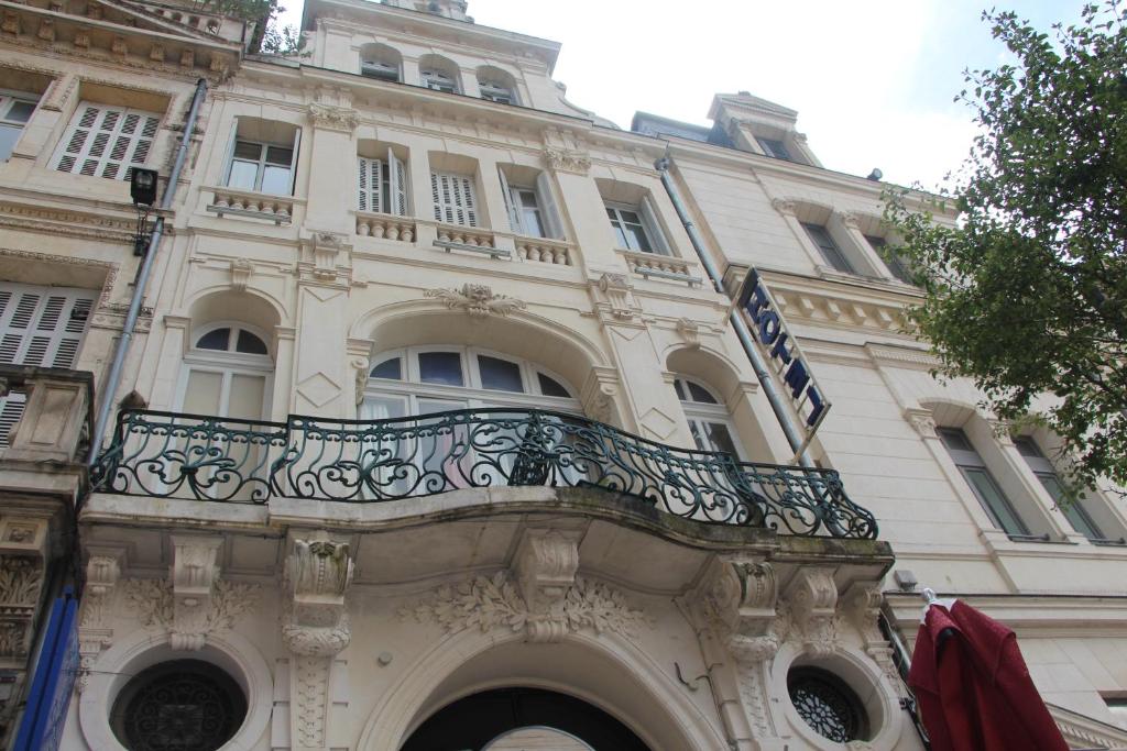 a building with a balcony on the side of it at Hotel Au Chapon Fin in Poitiers