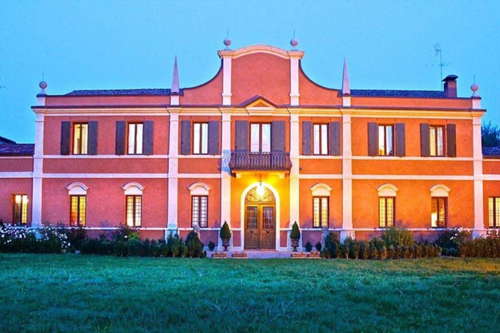 una gran casa naranja con un gran patio en Villa Contessa Massari Ferrara, en Ferrara