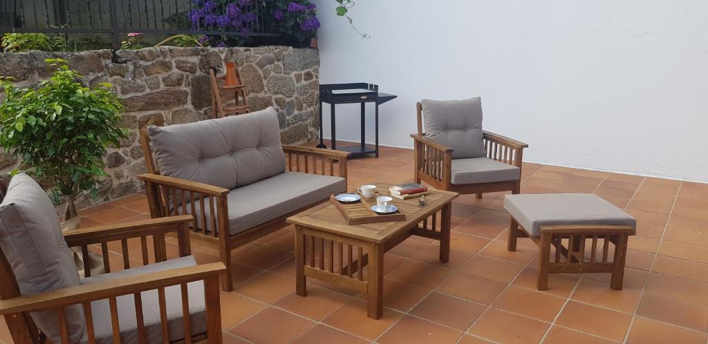 un patio con sillas, mesa de centro y piano en O FOGAR DE MARTIÑO, en Vilagarcía de Arousa