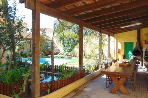 een veranda van een huis met een zwembad en een tafel bij Casa Mestre in Vila do Bispo