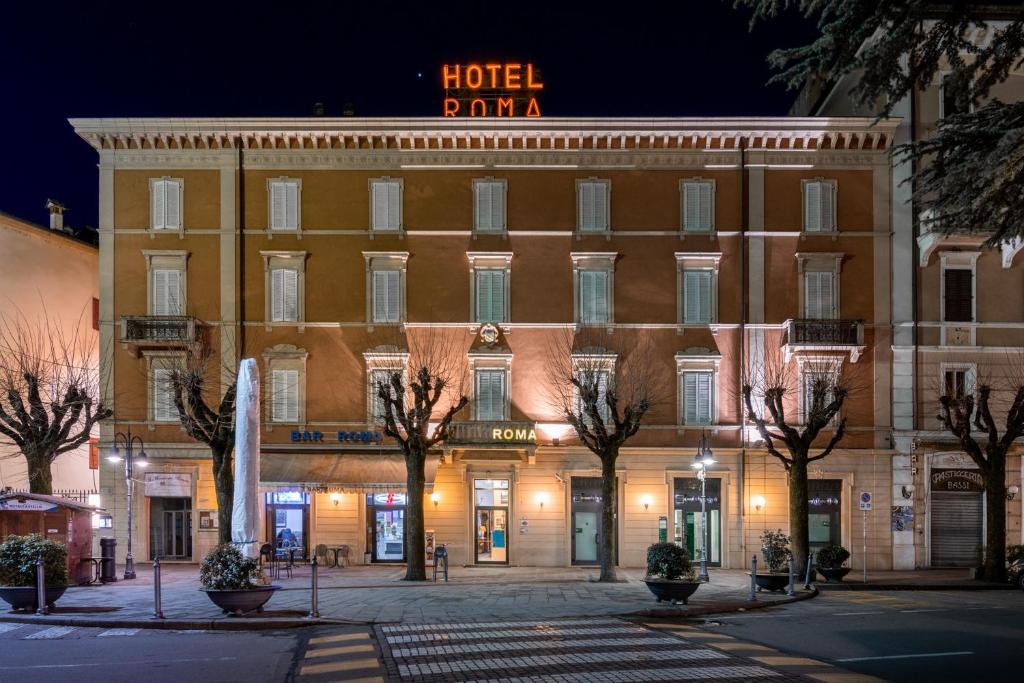un palma dell'hotel è illuminato di notte di Hotel Roma a Porretta Terme