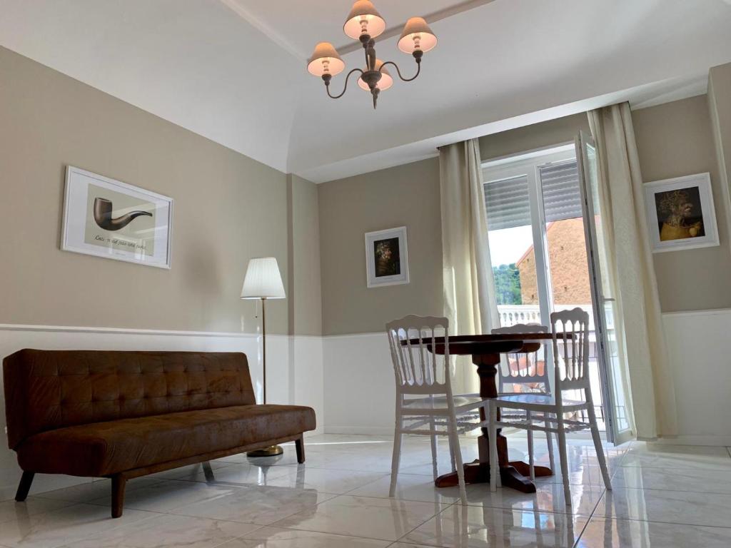 sala de estar con sofá, mesa y sillas en Cilento Suite - Louis XXII, en Agropoli