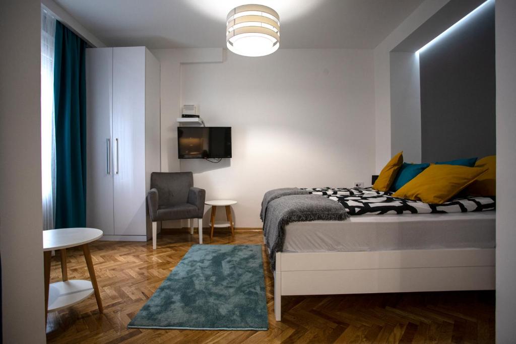 - une chambre avec un lit, une table et une chaise dans l'établissement DK Apartment, à Novi Sad