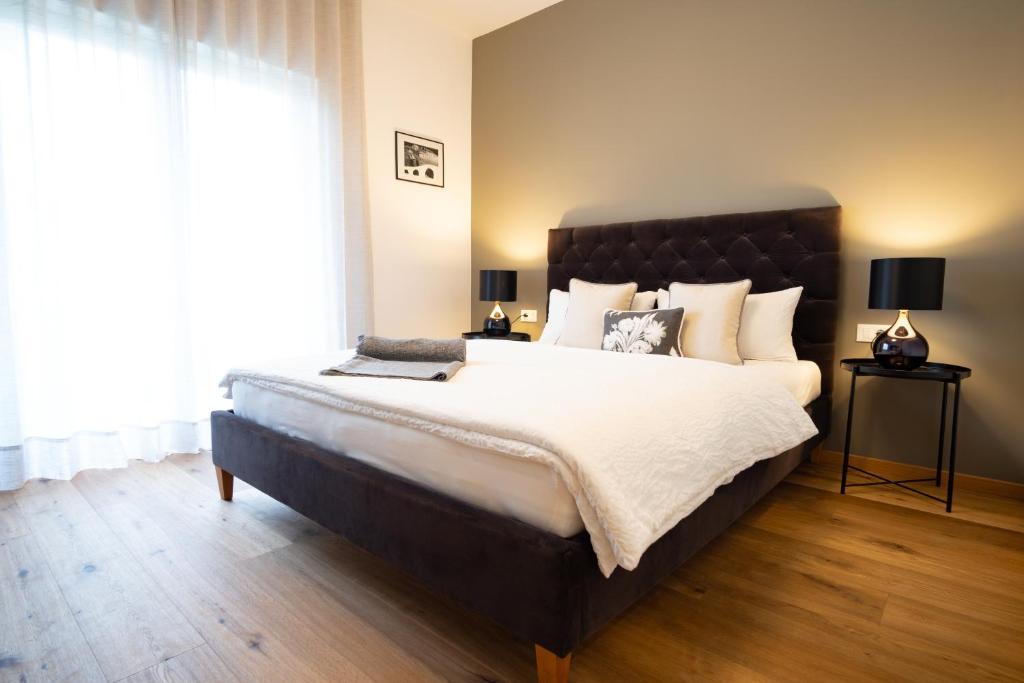 sypialnia z dużym łóżkiem i dużym oknem w obiekcie Apartment Hanna w Meranie