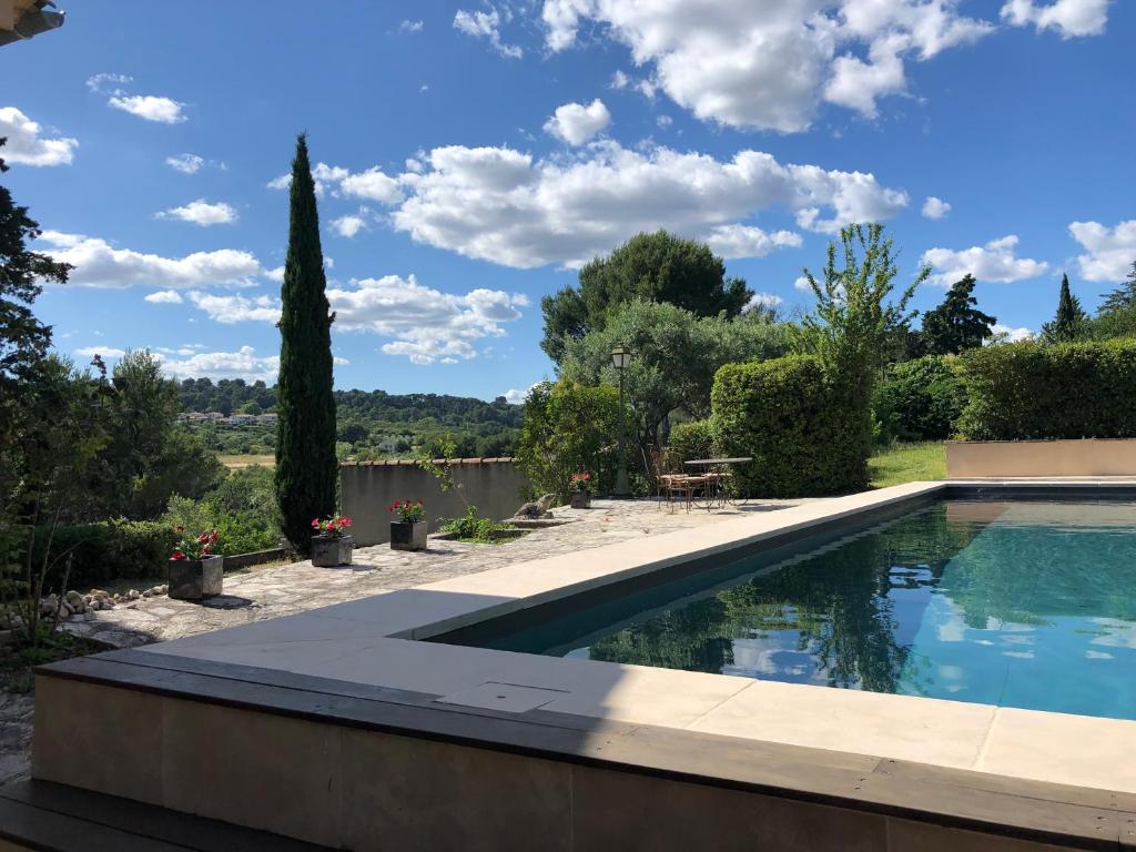 una piscina en un jardín con un techo alto en le Mas des Pignes -adults only en Aix-en-Provence
