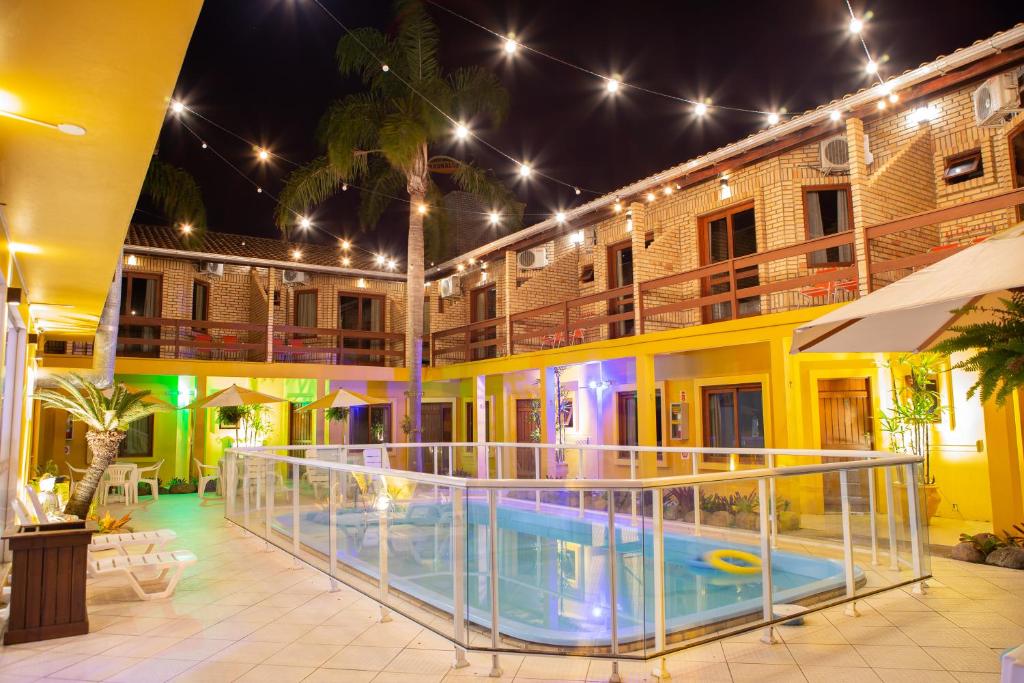 a hotel with a swimming pool at night at Pousada Maunaloa in Garopaba