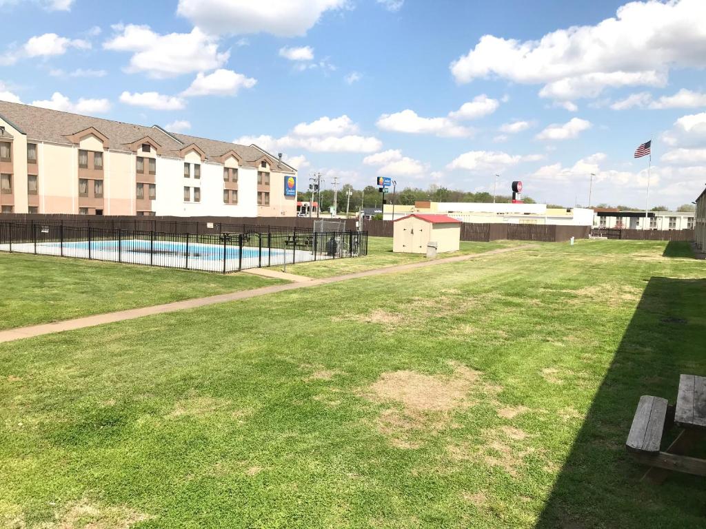 a park with a swimming pool and a building at Days Inn by Wyndham Joplin in Joplin