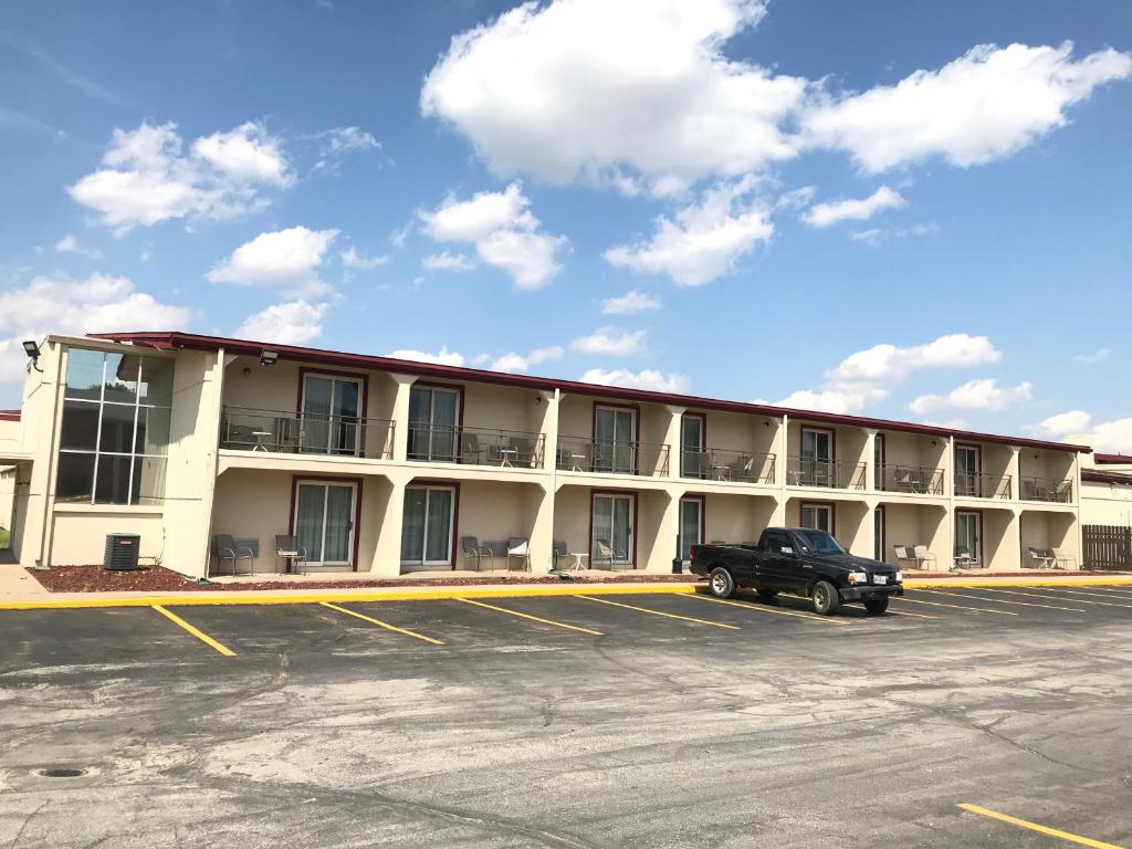 a large building with a truck parked in a parking lot at Days Inn by Wyndham Joplin in Joplin
