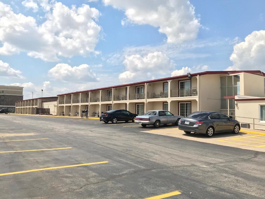 a parking lot with cars parked in front of a building at Days Inn by Wyndham Joplin in Joplin