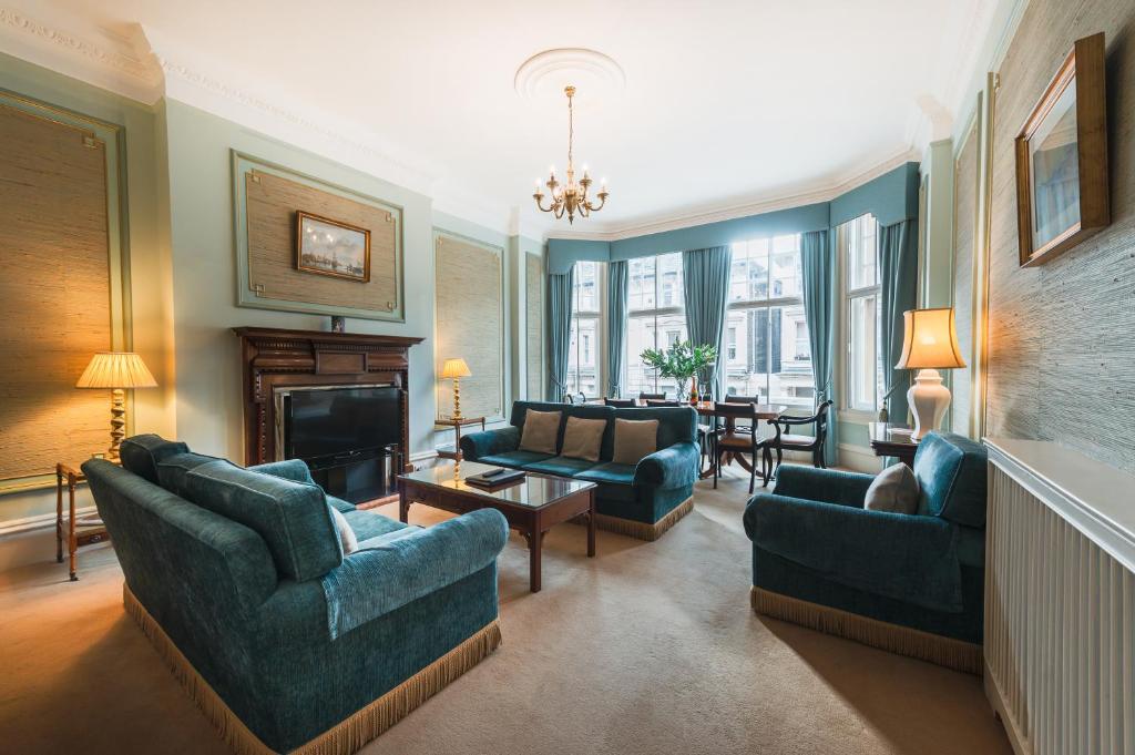 a living room with blue furniture and a fireplace at No1 The Mansions By Mansley in London