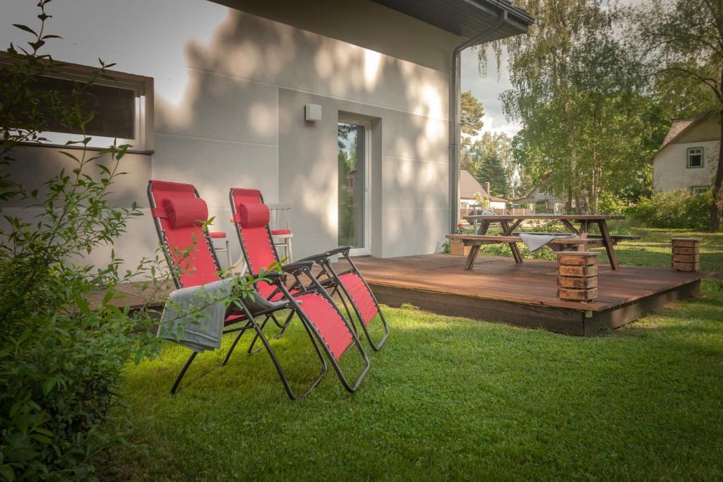 two chairs and a table on a wooden deck at Lauku iela 25 in Jūrmala