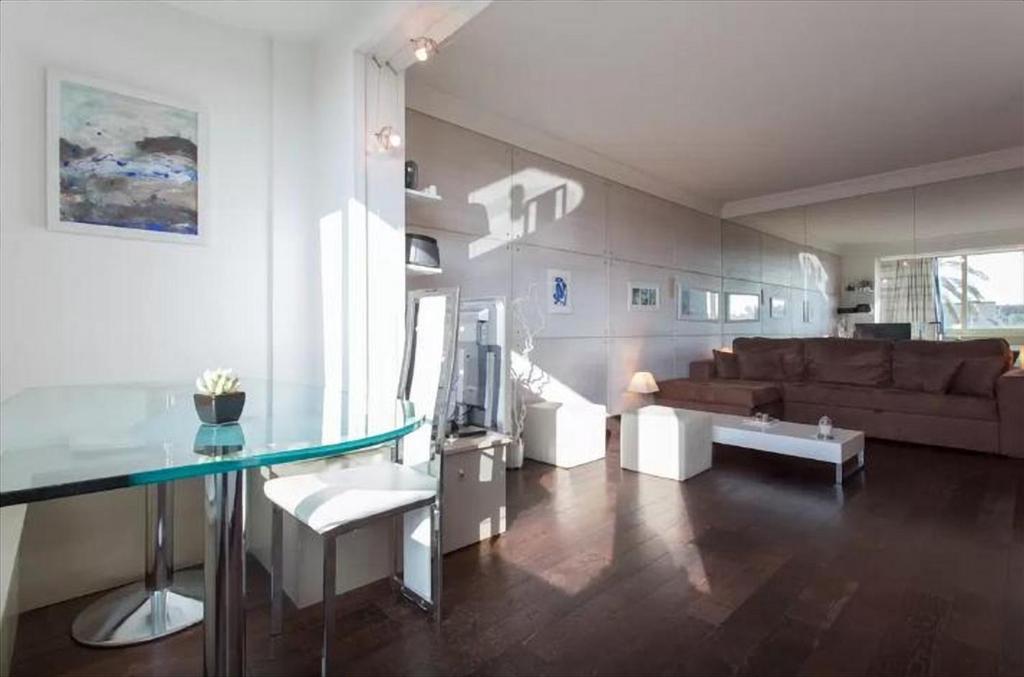 salon ze szklanym stołem i kanapą w obiekcie Residence Saint Marc w Cannes