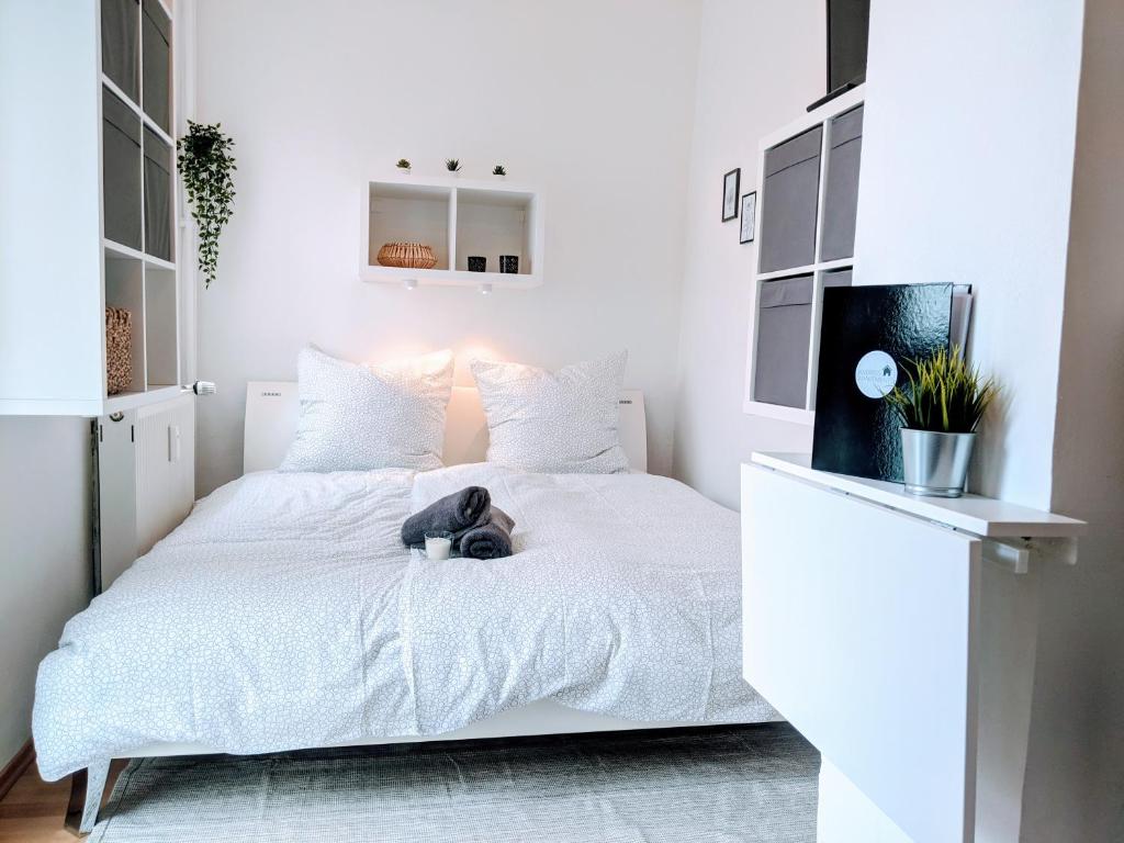 a bedroom with a white bed with a stuffed animal on it at Tiny Apartment - Innenstadt l Smart TV l Küche in Kaiserslautern