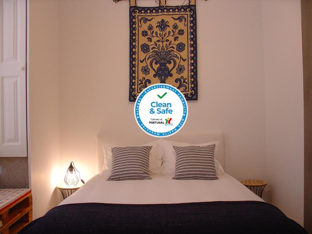 een slaapkamer met een bed met een bord dat zegt schoon en veilig bij Downtown Historical Apartment in Porto
