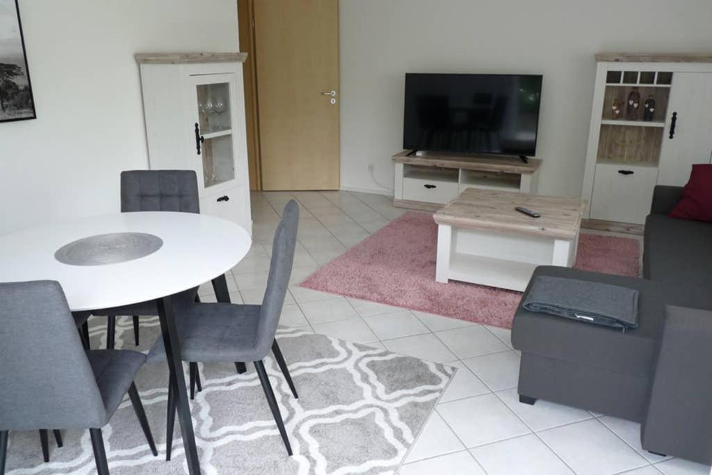 a living room with a table and chairs and a tv at Ferienwohnung Schwarzwaldrand in Nagold