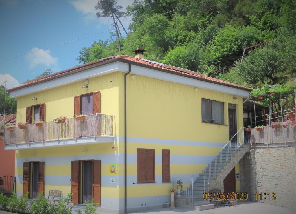 a yellow house with a balcony and a staircase at AMICI Holiday B&B di Bielak Aneta Izabela in Vezzano Ligure
