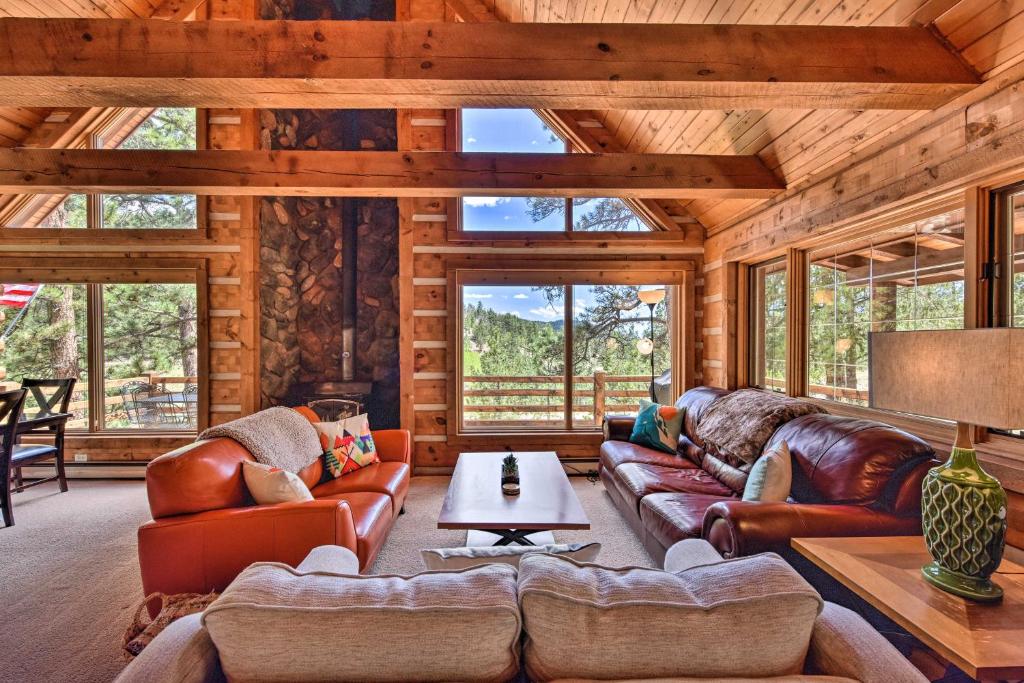 a living room with leather furniture in a log cabin at Quiet Guffey Getaway with Private Deck, Pond and Canoe in Guffey
