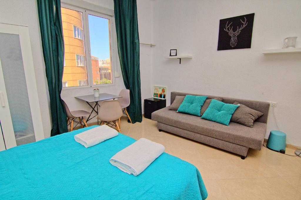 uma sala de estar com duas camas e um sofá em Low cost room Mercado Malaga em Málaga