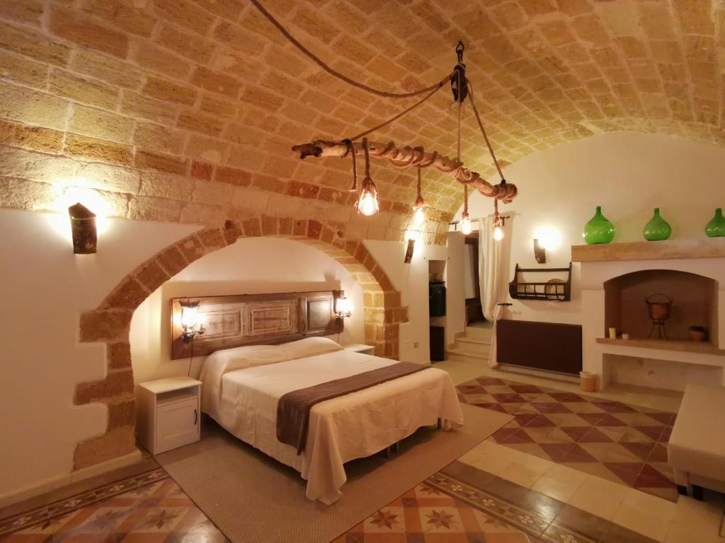 ein Schlafzimmer mit einem Bett in einem Zimmer mit Steinwänden in der Unterkunft Anna 1924 in Gagliano del Capo