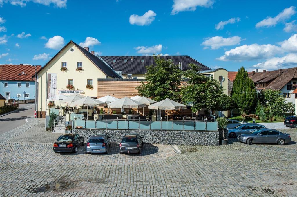 a parking lot with cars parked in front of a building at Hotel Gasthof Fenzl in Steinberg