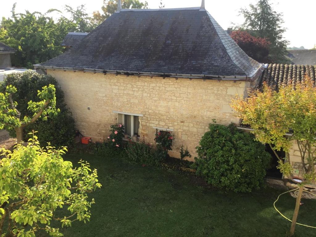 ein altes Backsteinhaus mit einem Fenster und einem Hof in der Unterkunft La Tour de Gué in Mirebeau