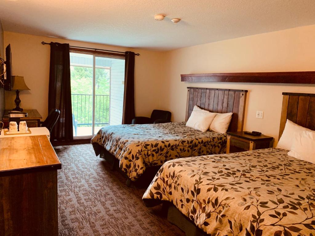 a hotel room with two beds and a window at Three Valley Lake Chateau in Revelstoke