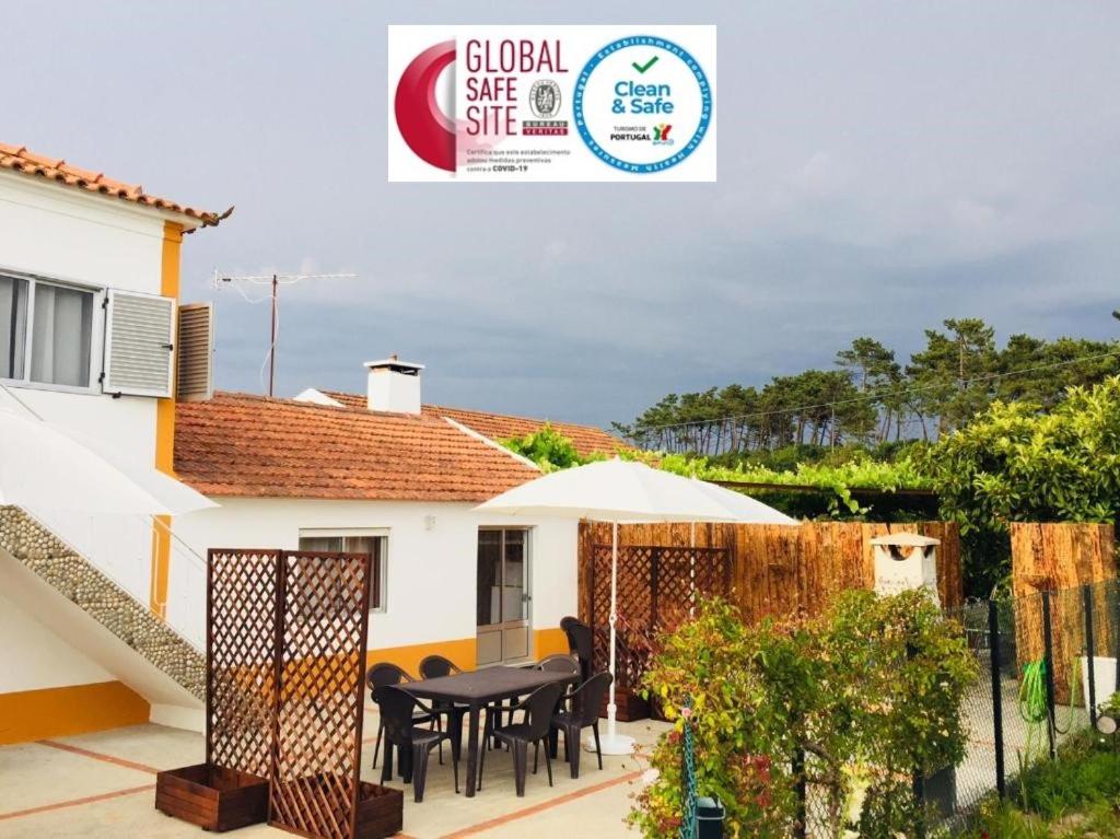 Cette maison dispose d'une terrasse avec une table et des chaises. dans l'établissement Casa dos Avos, à Ovar